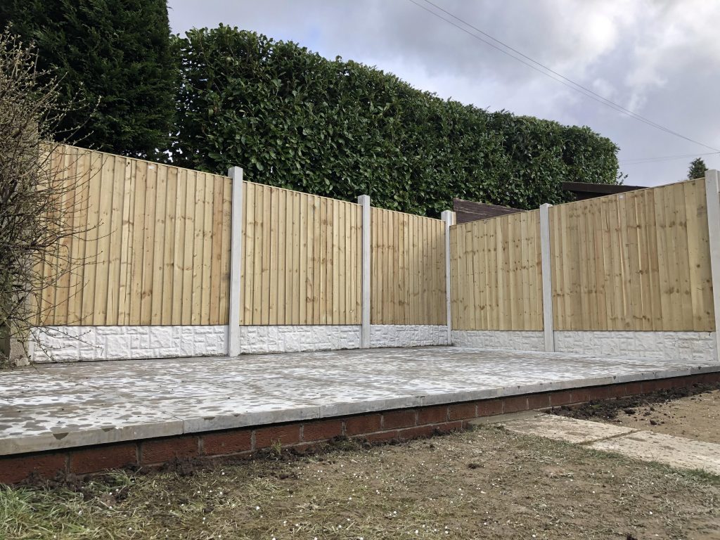 A fencing system composed of white concrete posts and gravel boards with sandy-coloured solid pine fence panels. This provides a fresh and clean finish while providing privacy and protection.